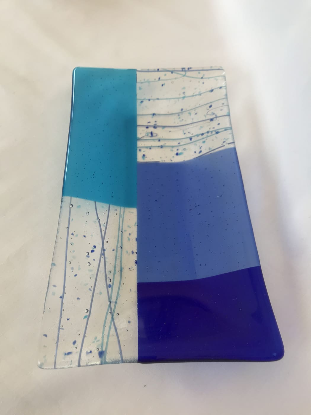 Fused glass dish in turquoise and violet with white streaks